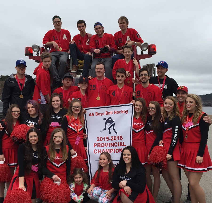 Viking players, cheerleaders, and coaches celebrating the win with their banner after a motorcade