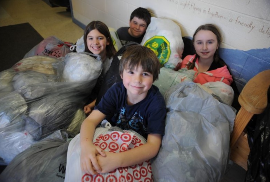 (L-R) Keira Parrill, Ewan Jenkins (front), Rhys Cormier, and Izabelle Jones pose with just a few of the bags created through their efforts (Photo credit: The Western Star)